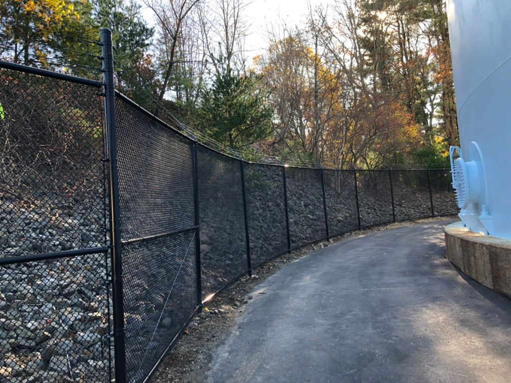 Black chain link fence along a paved path