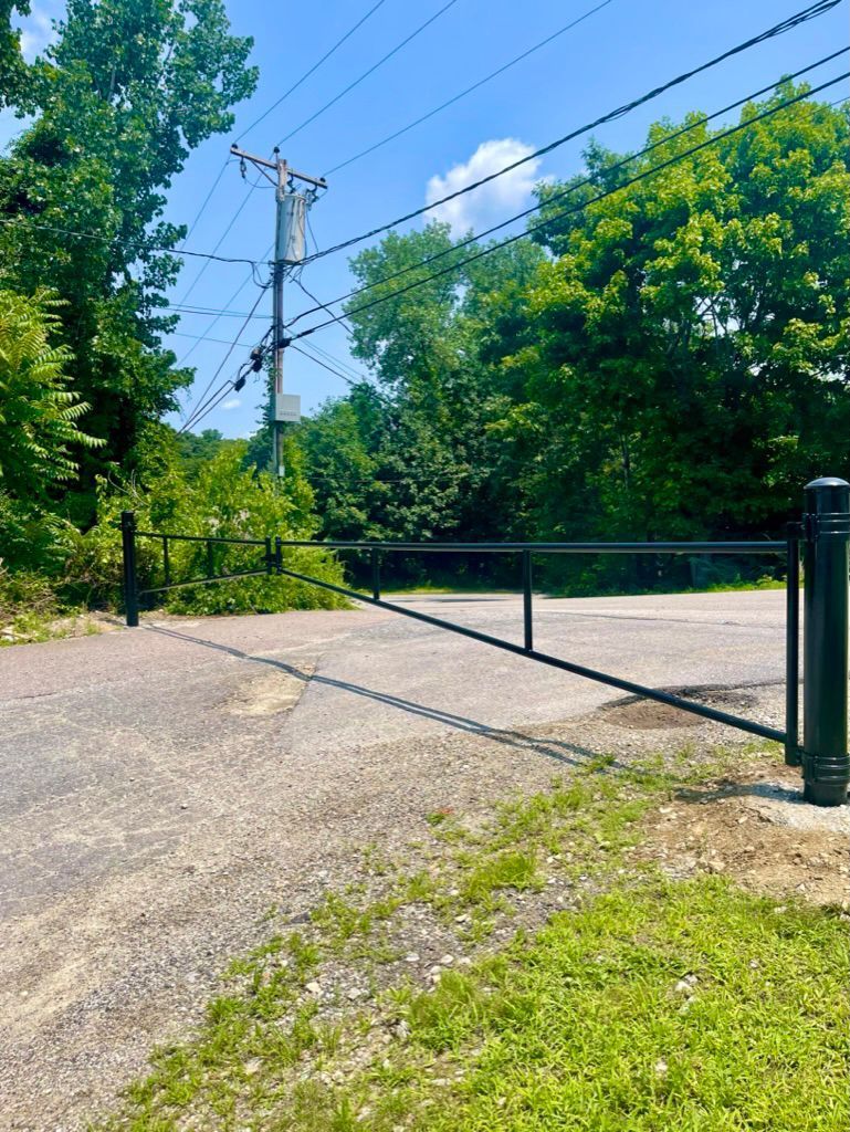 Black swing bar gate across a driveway
